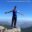 The person standing open-armed on mountain peak